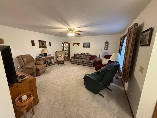 living room featuring ceiling fan, light colored carpet, and a textured ceiling