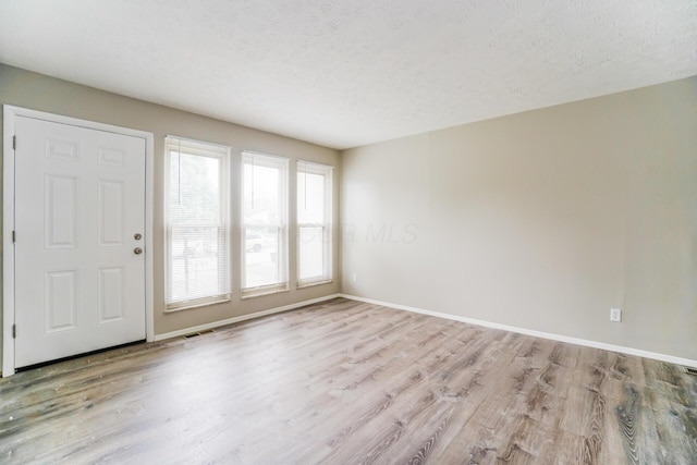 foyer featuring a textured ceiling and light wood-type flooring