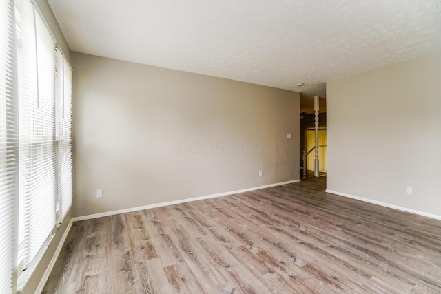 spare room with wood-type flooring and a textured ceiling