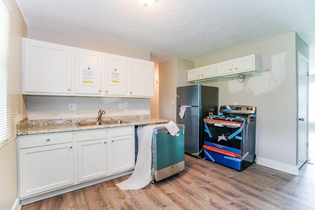 kitchen featuring black electric range oven, sink, and white cabinets