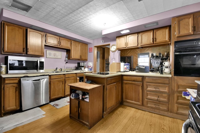 4417 Beechgrove Rd, Bucyrus, OH 44820 - kitchen featuring kitchen peninsula, appliances with stainless steel finishes, light hardwood / wood-style floors, and sink