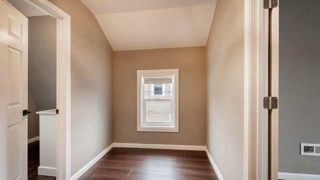 unfurnished room featuring dark hardwood / wood-style flooring and vaulted ceiling