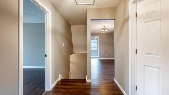 hall with dark hardwood / wood-style floors and a textured ceiling