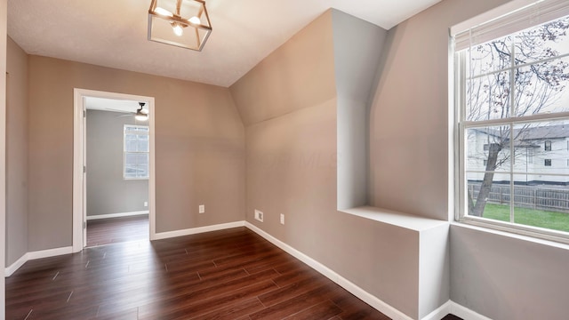 unfurnished room with dark wood-type flooring, ceiling fan, and a healthy amount of sunlight