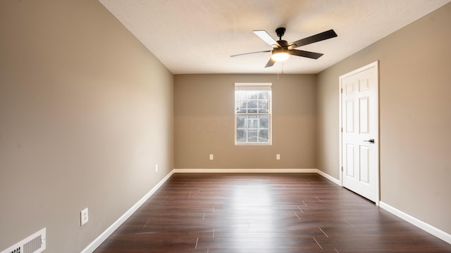 spare room with a textured ceiling, ceiling fan, and dark wood-type flooring