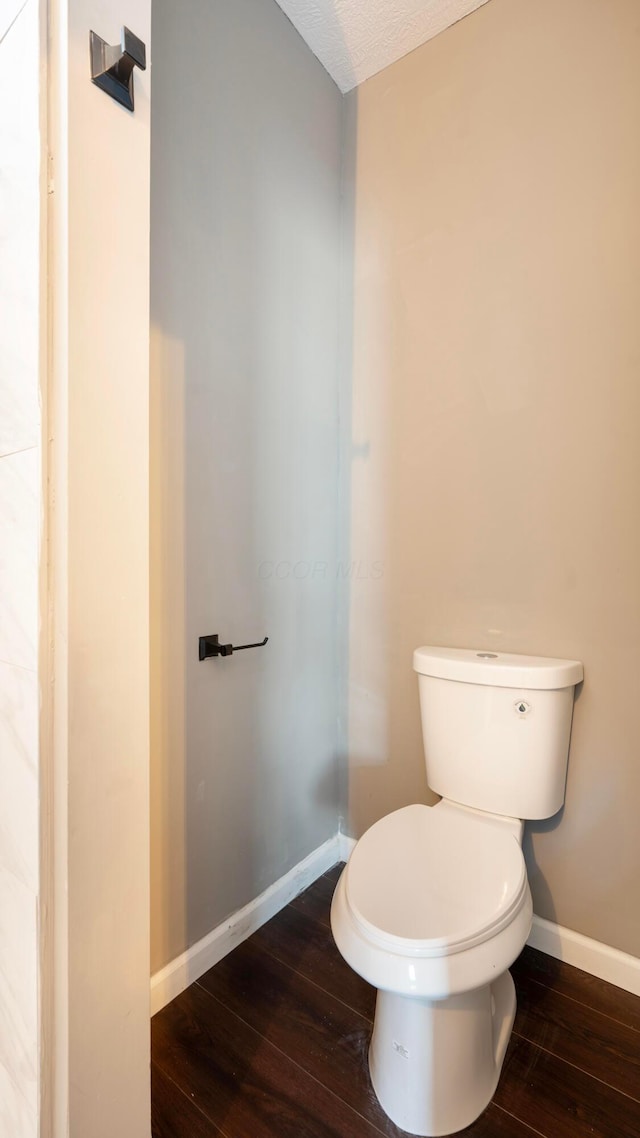 bathroom featuring hardwood / wood-style floors, a textured ceiling, and toilet