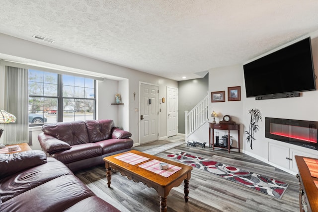 living room featuring wood-type flooring and a textured ceiling