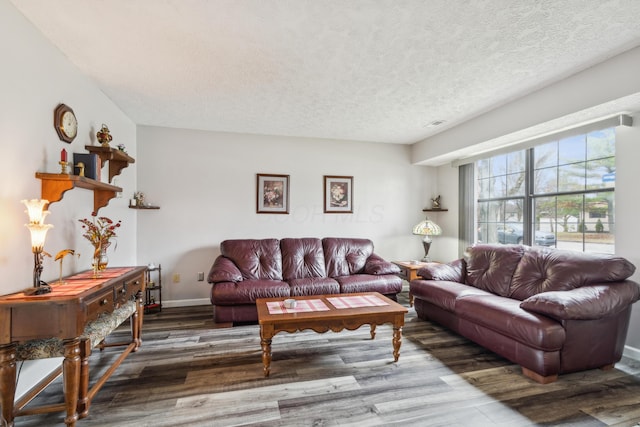 living room with a textured ceiling and dark hardwood / wood-style floors