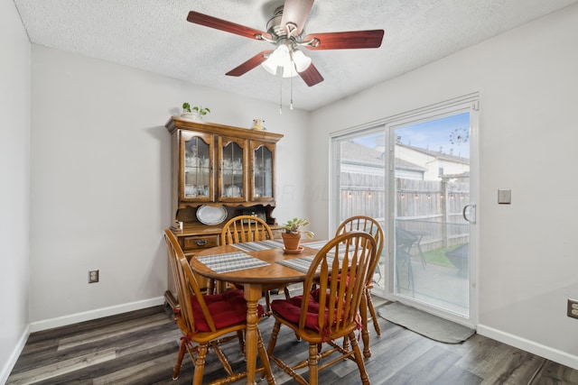 dining room featuring dark hardwood / wood-style floors, ceiling fan, and a textured ceiling