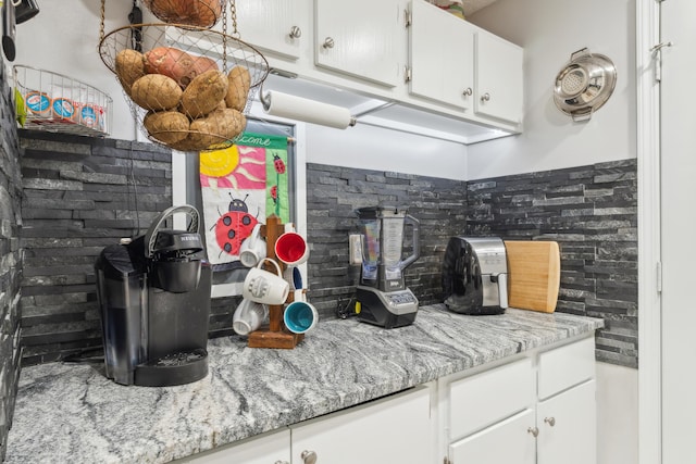 kitchen featuring white cabinetry and light stone countertops