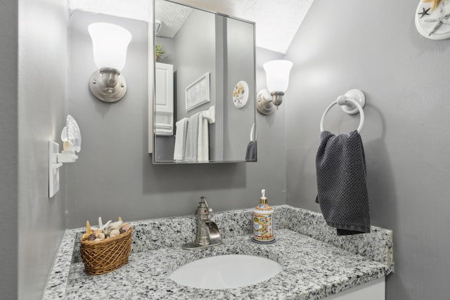 bathroom with vanity and lofted ceiling