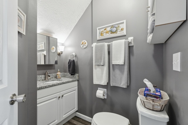 bathroom with vanity, a textured ceiling, and toilet