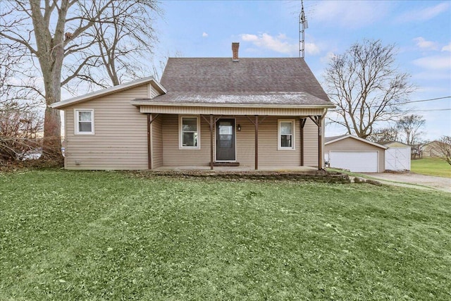 view of front of property with a front yard, a porch, a garage, and an outdoor structure