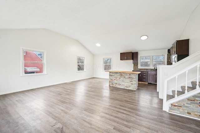 unfurnished living room with dark hardwood / wood-style flooring and vaulted ceiling