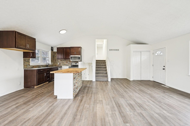 kitchen featuring wooden counters, stainless steel appliances, dark brown cabinets, and light hardwood / wood-style flooring