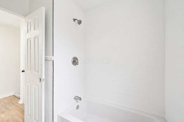 bathroom with tiled shower / bath and hardwood / wood-style flooring