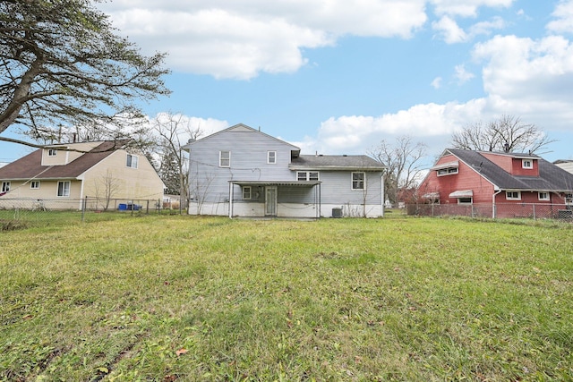 rear view of house featuring a yard