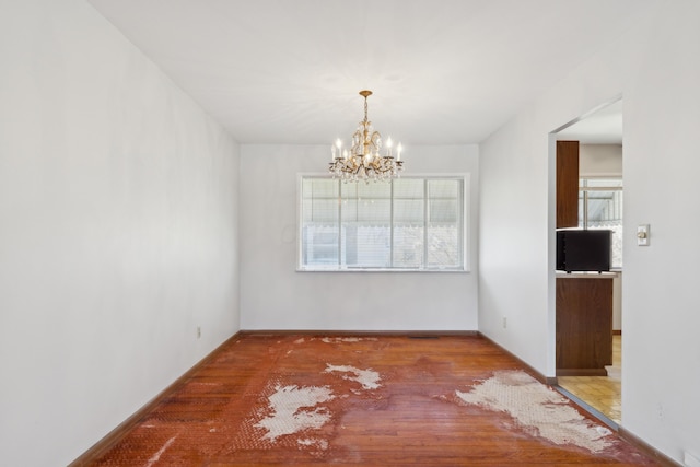 unfurnished dining area featuring hardwood / wood-style flooring and a chandelier