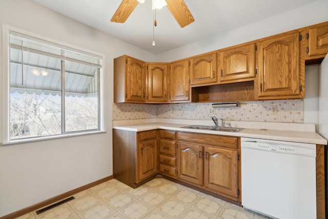 kitchen featuring ceiling fan, dishwasher, sink, and backsplash