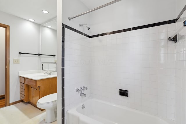 full bathroom featuring vanity, tiled shower / bath, and toilet