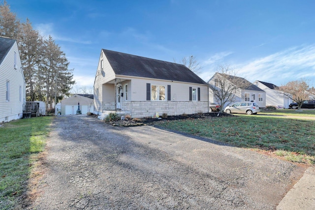 bungalow-style house featuring a garage, an outbuilding, and a front lawn