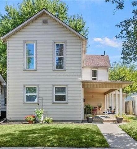 rear view of house featuring a yard and a patio area