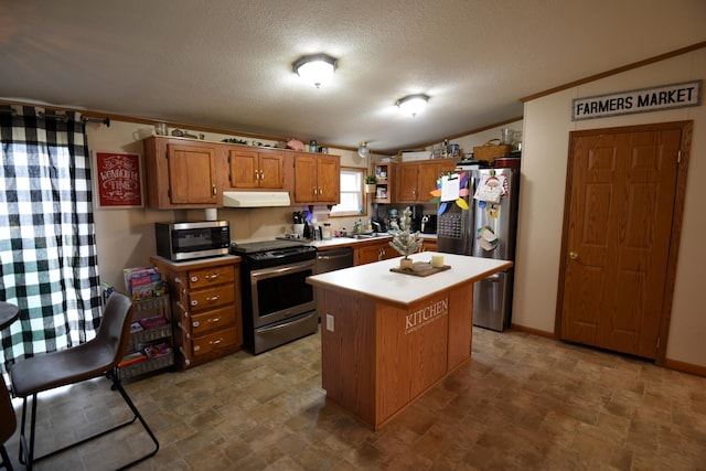 kitchen featuring a center island, stainless steel appliances, crown molding, lofted ceiling, and a textured ceiling