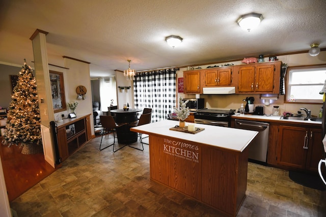 kitchen featuring a textured ceiling, decorative light fixtures, a kitchen island, and stainless steel appliances