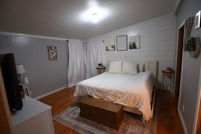 bedroom featuring hardwood / wood-style floors, a textured ceiling, and lofted ceiling