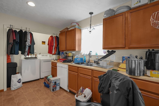 kitchen featuring sink, washer and clothes dryer, white dishwasher, a textured ceiling, and decorative light fixtures