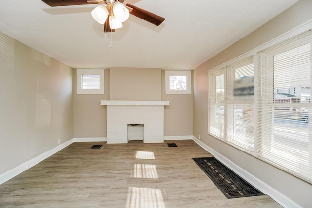 unfurnished living room featuring ceiling fan, light hardwood / wood-style floors, and a fireplace