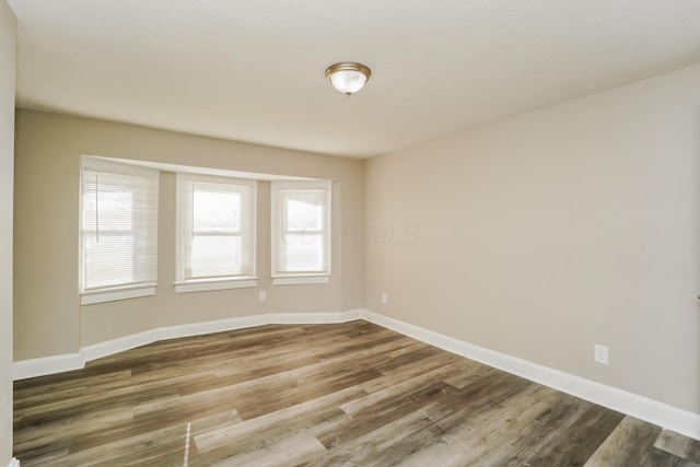 unfurnished room with hardwood / wood-style floors