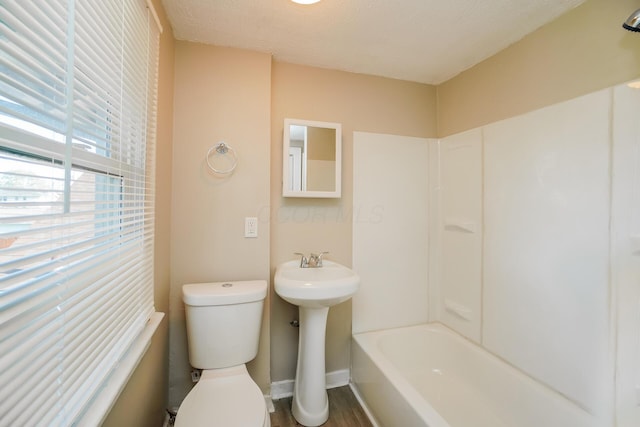 bathroom with hardwood / wood-style flooring, sink, a textured ceiling, and toilet