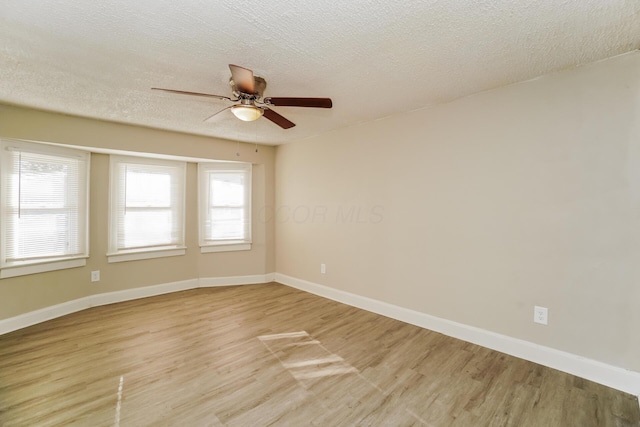 spare room featuring ceiling fan, light hardwood / wood-style floors, and a textured ceiling