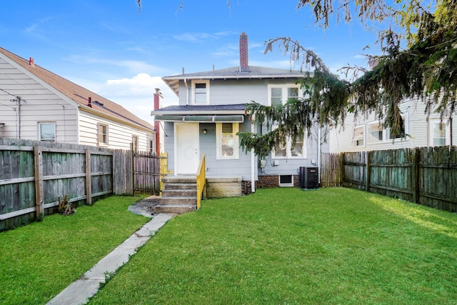 rear view of house featuring a lawn and central AC unit