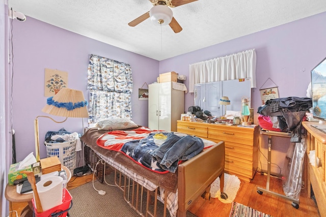 bedroom with ceiling fan and a textured ceiling