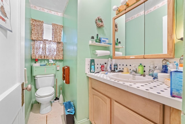 bathroom with tile patterned floors, vanity, tasteful backsplash, and toilet