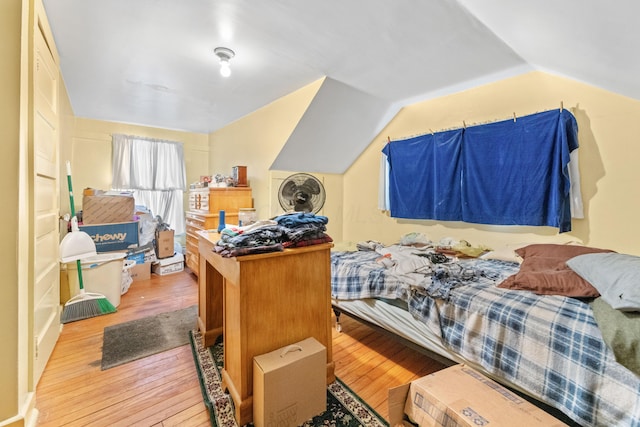 bedroom featuring light wood-type flooring and vaulted ceiling