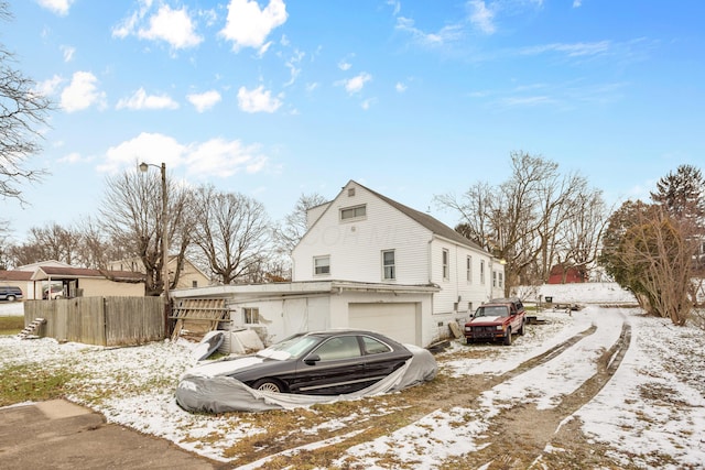 view of snow covered exterior with a garage