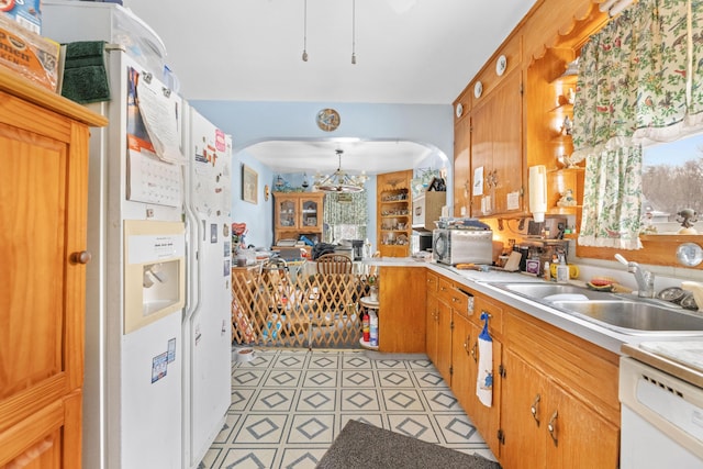 kitchen featuring pendant lighting, white dishwasher, an inviting chandelier, and sink