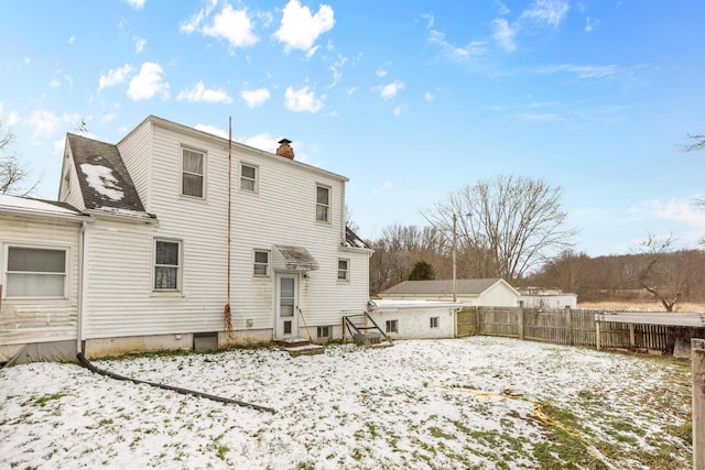 view of snow covered back of property