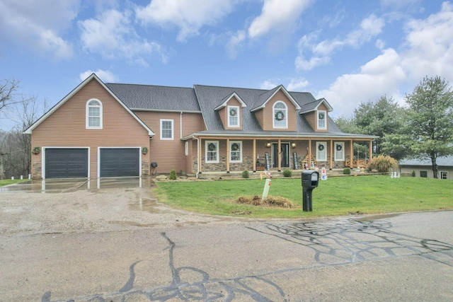 cape cod home featuring covered porch, a garage, and a front yard