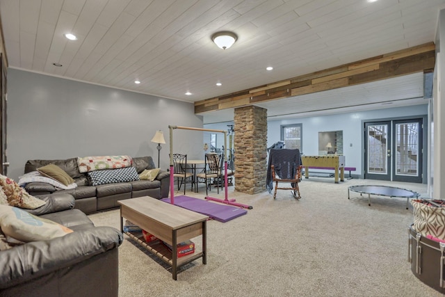 carpeted living room with decorative columns, ornamental molding, and wooden ceiling