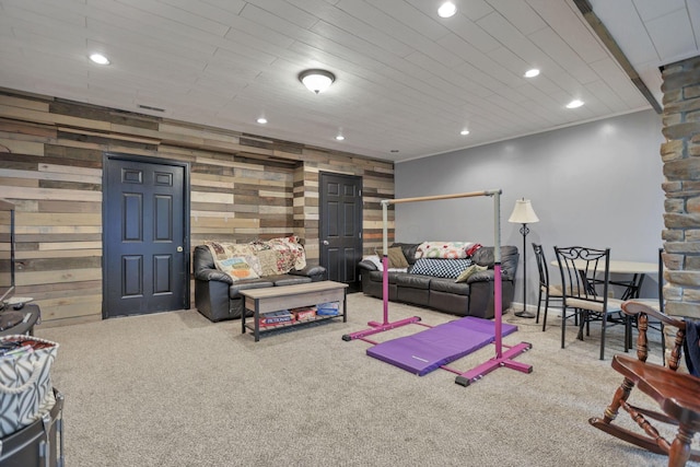 carpeted living room with wood walls