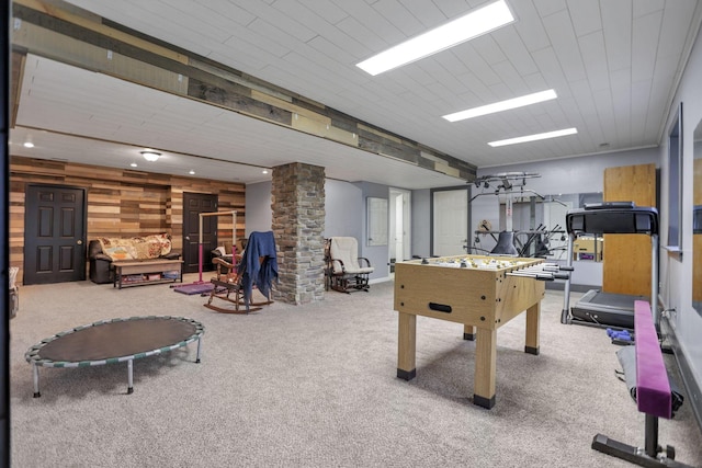 rec room with ornate columns, light carpet, and wooden walls