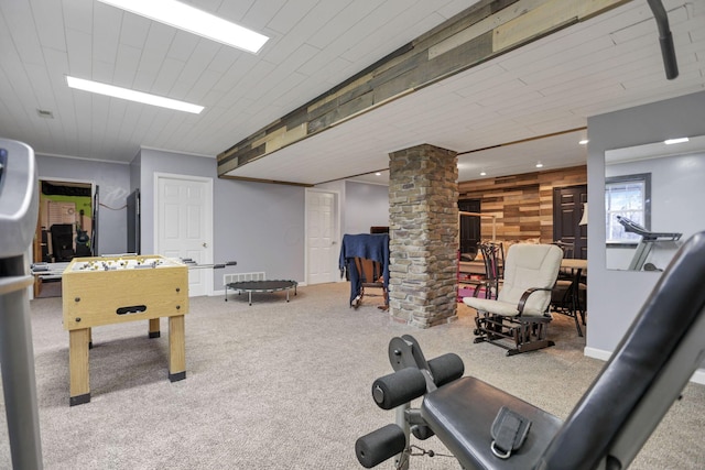 rec room with wood walls, light colored carpet, and decorative columns