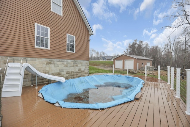 wooden deck featuring a garage and an outdoor structure