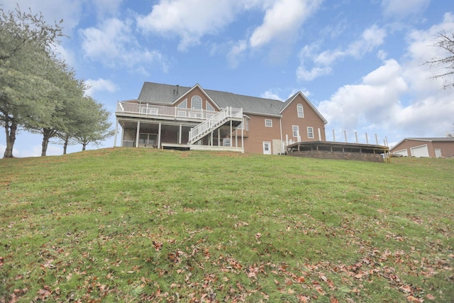 back of property with a yard and a sunroom