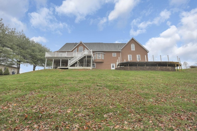 rear view of property with a deck and a lawn