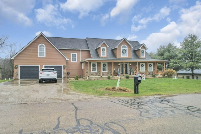 view of front of property with covered porch, a garage, and a front lawn